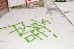 Grüne Graffitis auf den neuen hell grauen Pflastersteine an dem Boulevard (Hauptstrasse in Oyten)